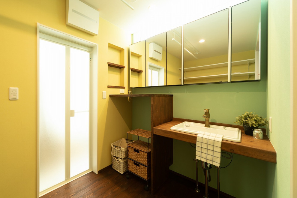 神戸にあるインダストリアルスタイルのおしゃれなトイレ・洗面所 (緑の壁、濃色無垢フローリング、木製洗面台、茶色い床、ブラウンの洗面カウンター、造り付け洗面台、クロスの天井、壁紙) の写真