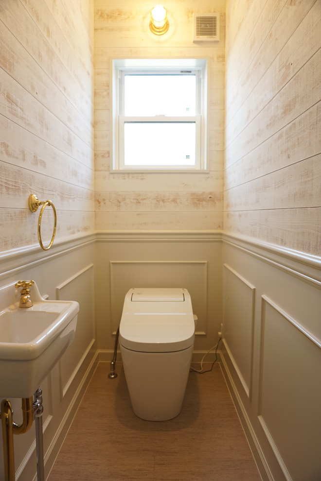 他の地域にあるおしゃれなトイレ・洗面所 (一体型トイレ	、白い壁) の写真