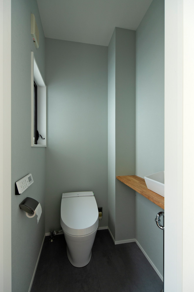 Exempel på ett litet nordiskt toalett, med öppna hyllor, en toalettstol med hel cisternkåpa, tunnelbanekakel, vita väggar, mellanmörkt trägolv, ett integrerad handfat och bänkskiva i akrylsten