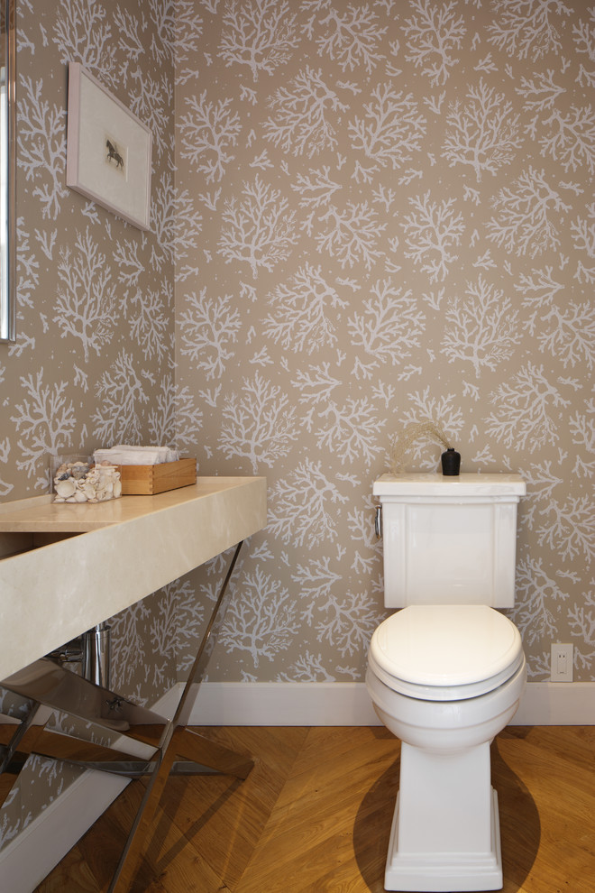 Aménagement d'un WC et toilettes avec WC séparés, un mur beige, un sol en bois brun, un sol marron et un plan de toilette beige.