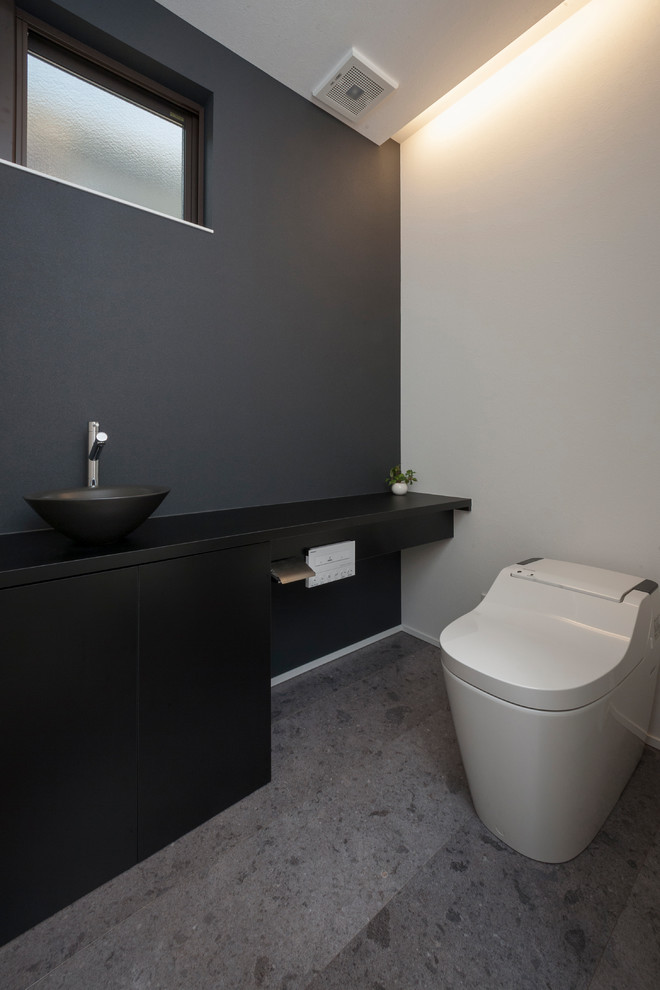 Imagen de aseo moderno con paredes grises, lavabo sobreencimera y suelo gris