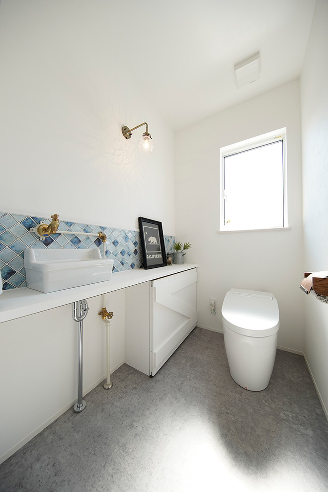 Example of a danish gray floor powder room design in Other with white walls and a vessel sink