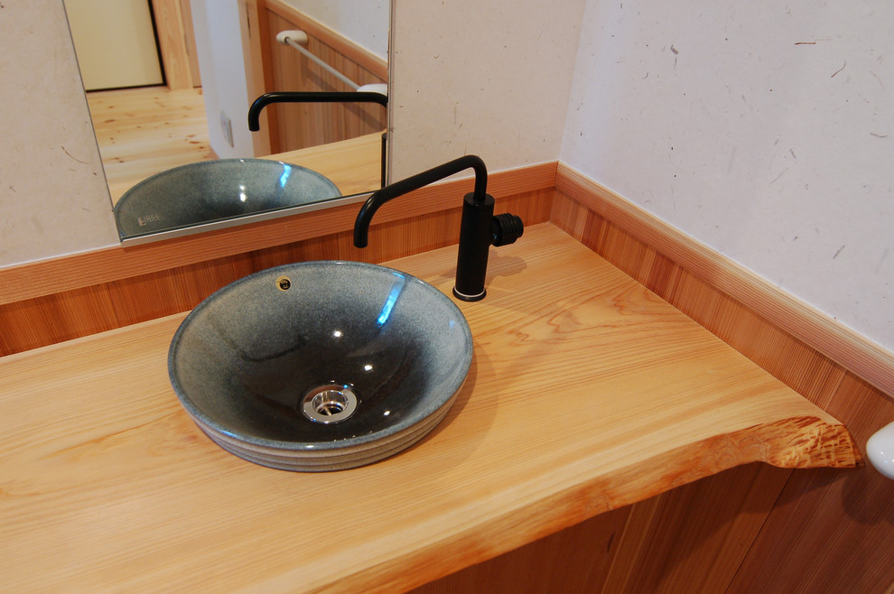 Ejemplo de aseo de estilo zen pequeño con lavabo encastrado, encimera de madera y encimeras beige