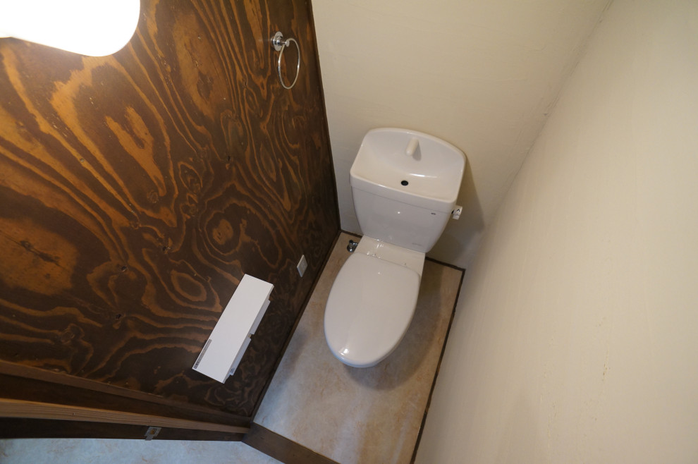 Nordisk inredning av ett litet toalett, med en toalettstol med separat cisternkåpa, vita väggar, vinylgolv och beiget golv