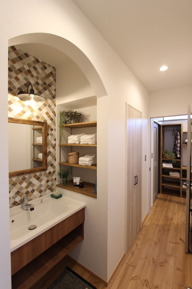 Retro Gästetoilette mit weißer Wandfarbe, dunklem Holzboden und braunem Boden in Sonstige
