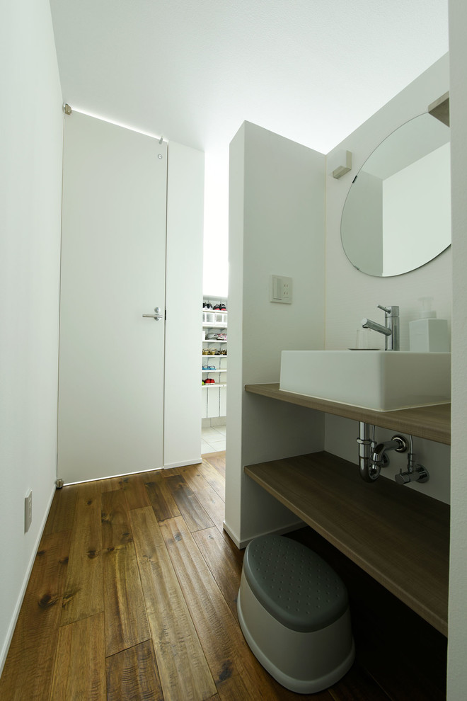 Esempio di un bagno di servizio moderno con pareti bianche, pavimento in vinile, lavabo a bacinella e top beige