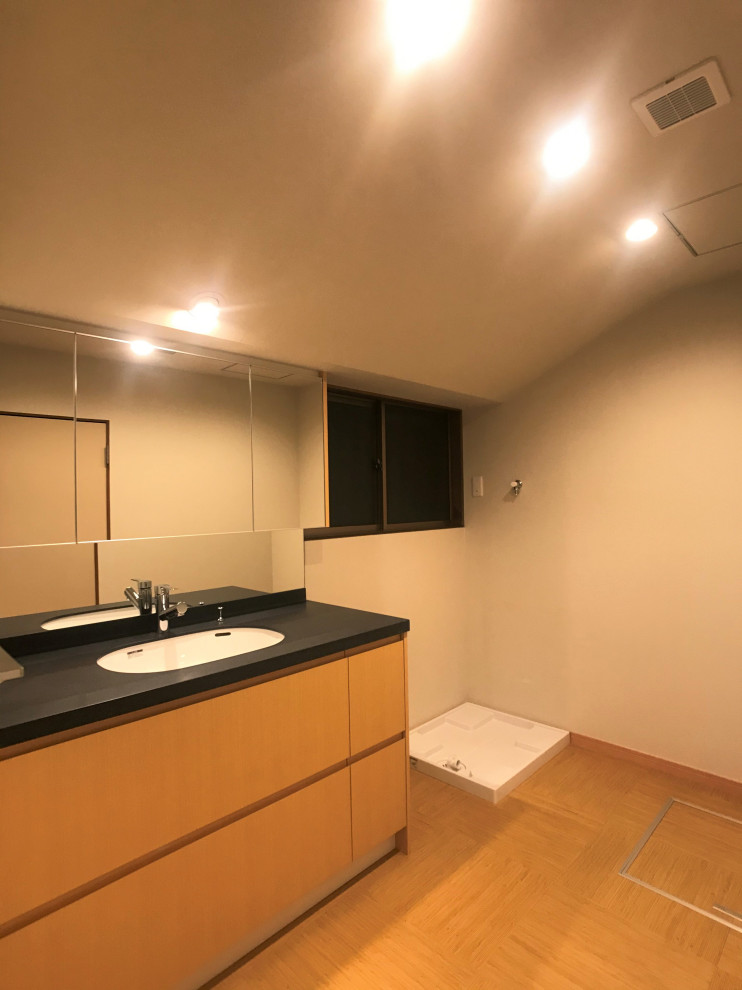 Idéer för ett mellanstort asiatiskt svart toalett, med släta luckor, skåp i mellenmörkt trä, vita väggar, bambugolv, ett undermonterad handfat, bänkskiva i akrylsten och beiget golv