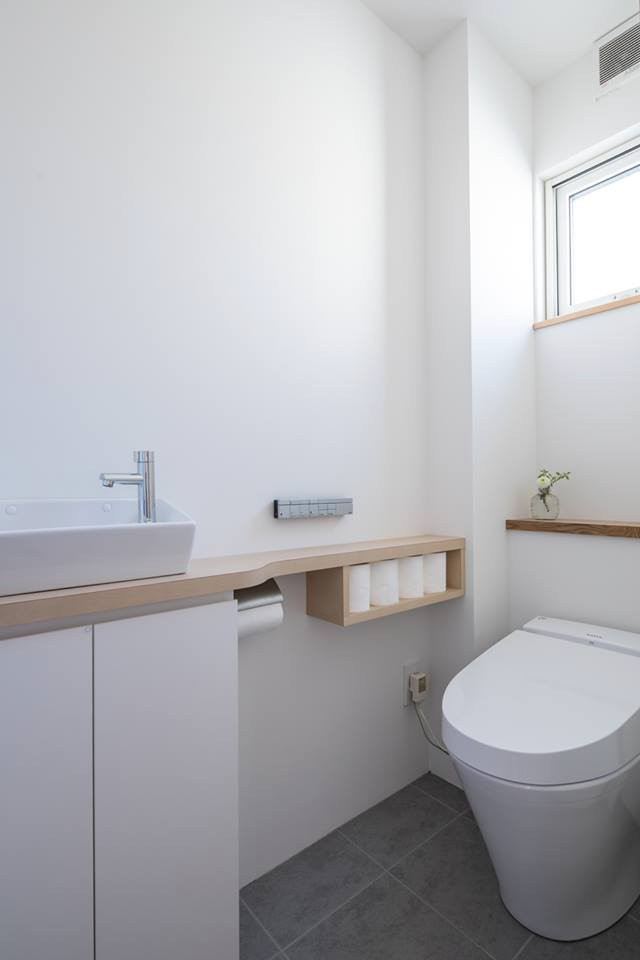 Kleine Asiatische Gästetoilette mit Toilette mit Aufsatzspülkasten, weißer Wandfarbe, Keramikboden, Einbauwaschbecken und grauem Boden in Sonstige
