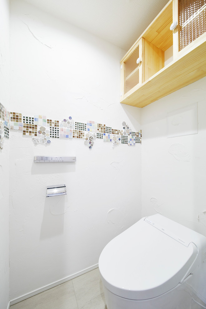 На фото: маленький туалет в стиле модернизм с стеклянными фасадами, бежевыми фасадами, унитазом-моноблоком, белой плиткой, плиткой мозаикой, белыми стенами и бежевым полом для на участке и в саду