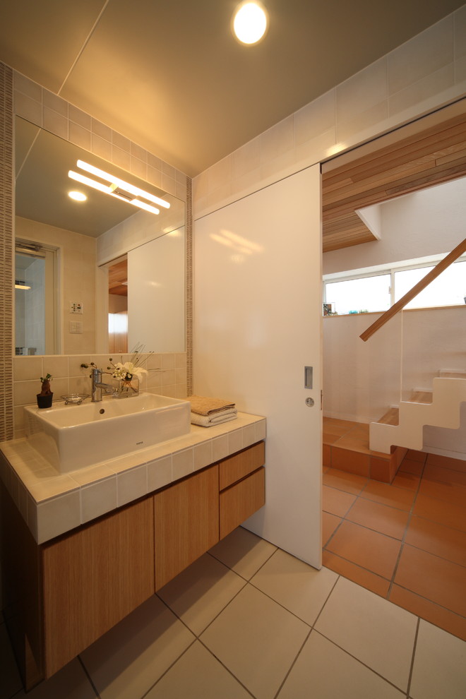 他の地域にある北欧スタイルのおしゃれなトイレ・洗面所 (フラットパネル扉のキャビネット、中間色木目調キャビネット、ベージュの壁、ベッセル式洗面器、ベージュの床) の写真