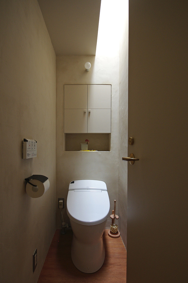 Inspiration pour un WC et toilettes sud-ouest américain avec un mur blanc et parquet foncé.