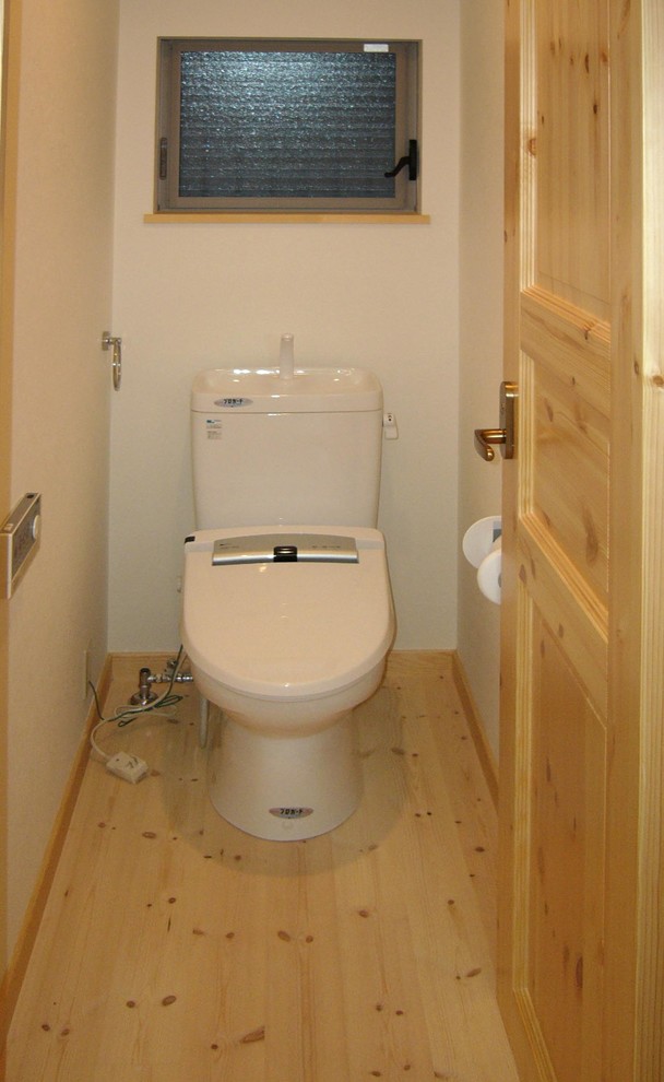 Idéer för ett mellanstort minimalistiskt toalett, med en toalettstol med separat cisternkåpa, vita väggar, ljust trägolv och beiget golv