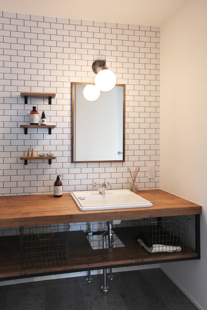 Inspiration for a small midcentury cloakroom in Other with white tiles, metro tiles, white walls, ceramic flooring, a built-in sink, black floors, brown worktops, open cabinets, distressed cabinets and wooden worktops.