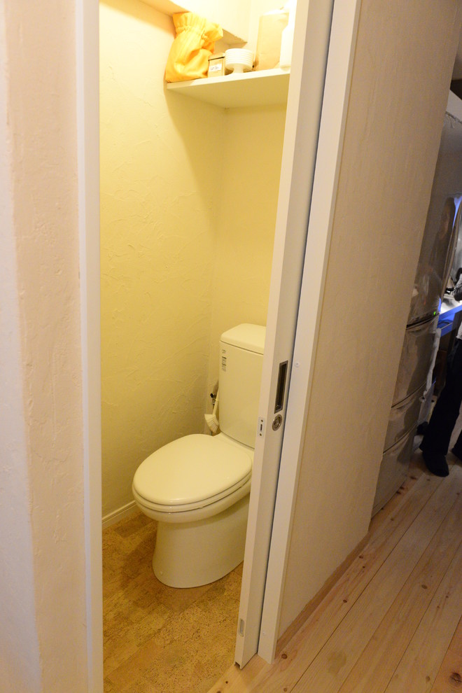 Ispirazione per un bagno di servizio moderno con WC a due pezzi, pareti bianche, pavimento in sughero, top in superficie solida e pavimento marrone