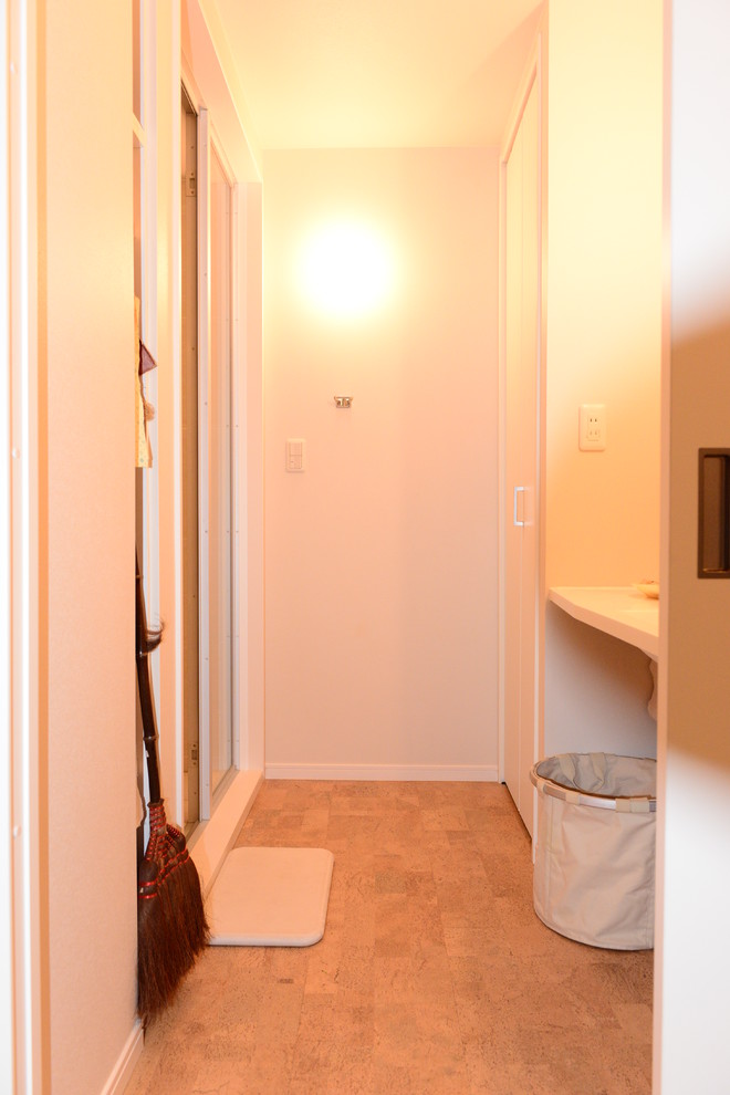 Exempel på ett modernt toalett, med vita väggar, korkgolv, bänkskiva i akrylsten, brunt golv och ett undermonterad handfat