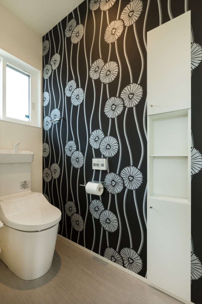 Idée de décoration pour un WC et toilettes minimaliste avec WC à poser, un mur noir et un sol beige.