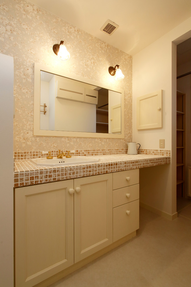 Landhaus Gästetoilette mit Schrankfronten mit vertiefter Füllung, weißen Schränken, bunten Wänden, Einbauwaschbecken und gefliestem Waschtisch in Sonstige