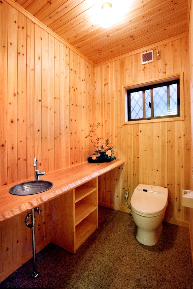 Foto på ett mellanstort orientaliskt beige toalett, med en toalettstol med separat cisternkåpa, beige väggar, träbänkskiva och rosa golv