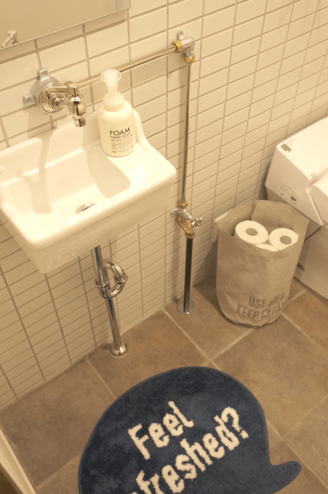 他の地域にあるインダストリアルスタイルのおしゃれなトイレ・洗面所 (白いタイル、白い壁、グレーの床) の写真