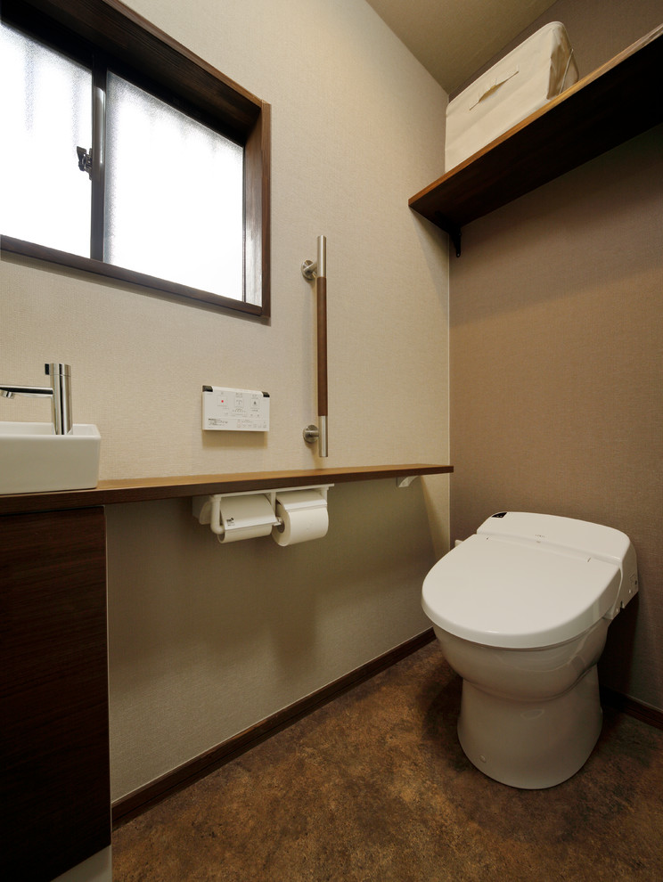 Asiatische Gästetoilette mit bunten Wänden, Aufsatzwaschbecken und braunem Boden in Sonstige