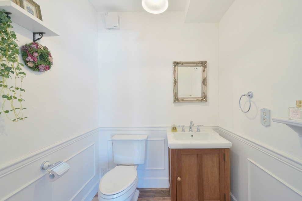Ispirazione per un bagno di servizio chic con ante in legno bruno, pareti bianche e lavabo a bacinella