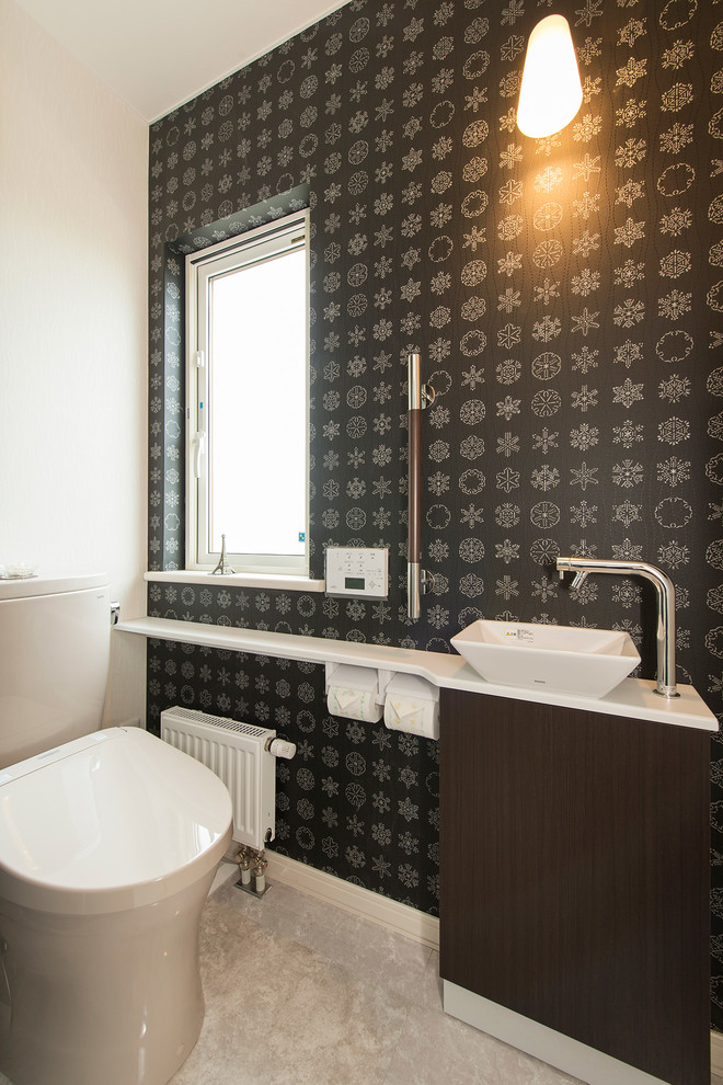 Immagine di un bagno di servizio minimal con pavimento grigio, ante lisce, ante marroni, WC monopezzo, pareti bianche e lavabo a bacinella