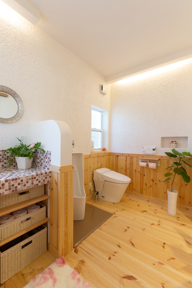 Asiatische Gästetoilette mit offenen Schränken, weißer Wandfarbe, braunem Holzboden, gefliestem Waschtisch und braunem Boden in Sonstige