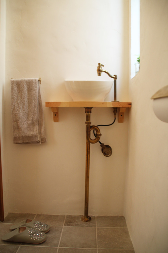 Пример оригинального дизайна: туалет в скандинавском стиле с полом из терракотовой плитки и серым полом