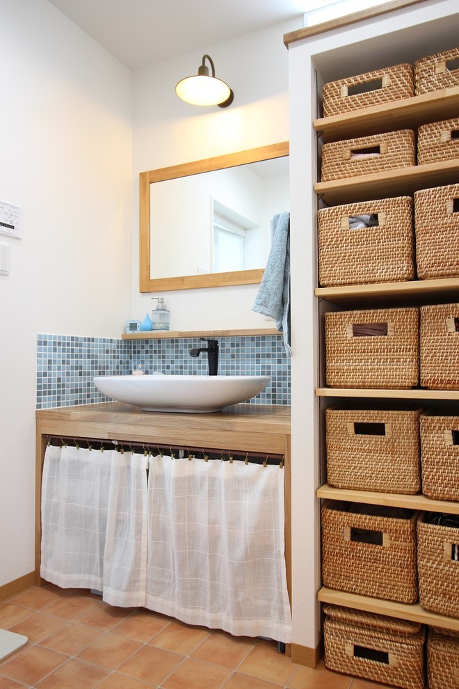 На фото: туалет в стиле кантри с белой плиткой, керамогранитной плиткой, полом из винила и коричневым полом