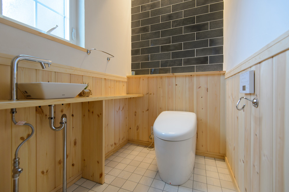 他の地域にある北欧スタイルのおしゃれなトイレ・洗面所 (マルチカラーの壁、ベッセル式洗面器、木製洗面台、ベージュの床、ベージュのカウンター) の写真