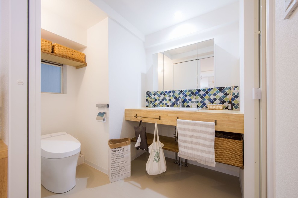 Imagen de aseo escandinavo con armarios abiertos, paredes blancas, lavabo encastrado, encimera de madera, suelo beige y encimeras beige