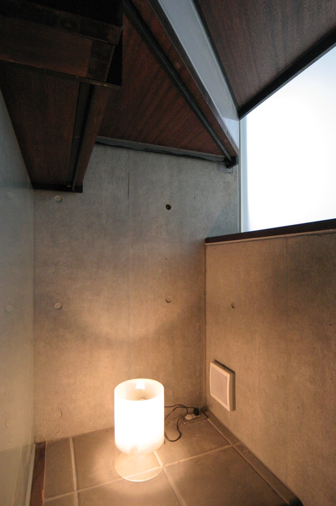 東京23区にあるお手頃価格の中くらいなモダンスタイルのおしゃれなトイレ・洗面所 (一体型トイレ	、グレーの壁、セラミックタイルの床、壁付け型シンク、木製洗面台、グレーの床) の写真