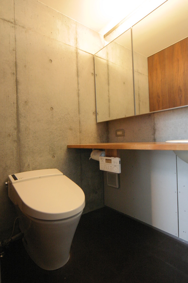 Inspiration för moderna toaletter, med luckor med glaspanel, en toalettstol med hel cisternkåpa, grå väggar, korkgolv, ett nedsänkt handfat, träbänkskiva och brunt golv
