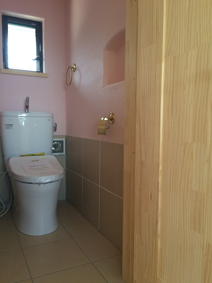 На фото: маленький туалет в стиле кантри с раздельным унитазом, бежевой плиткой, керамогранитной плиткой, розовыми стенами и полом из керамогранита для на участке и в саду с