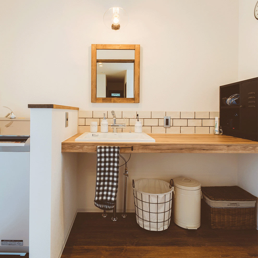 他の地域にあるインダストリアルスタイルのおしゃれなトイレ・洗面所 (白いタイル、サブウェイタイル、木製洗面台、白い壁、無垢フローリング、茶色い床、ブラウンの洗面カウンター) の写真