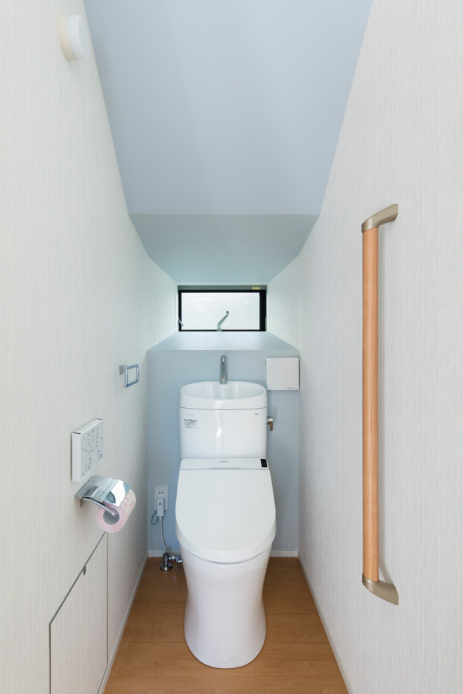 Foto de aseo moderno de tamaño medio con sanitario de una pieza, suelo de contrachapado, suelo blanco, papel pintado, papel pintado y paredes azules