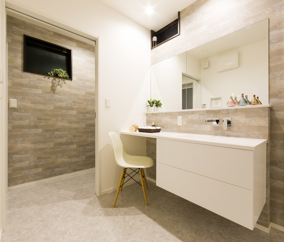 Idée de décoration pour un WC et toilettes design avec un sol gris, un lavabo intégré, un carrelage multicolore et un mur blanc.