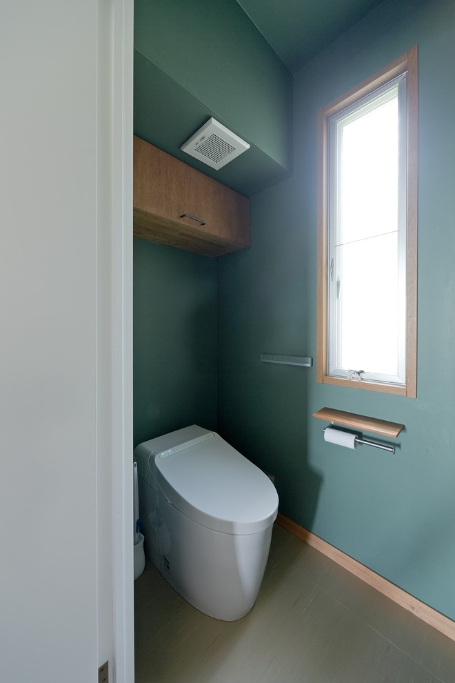 Réalisation d'un WC et toilettes urbain en bois brun de taille moyenne avec WC à poser et un mur vert.