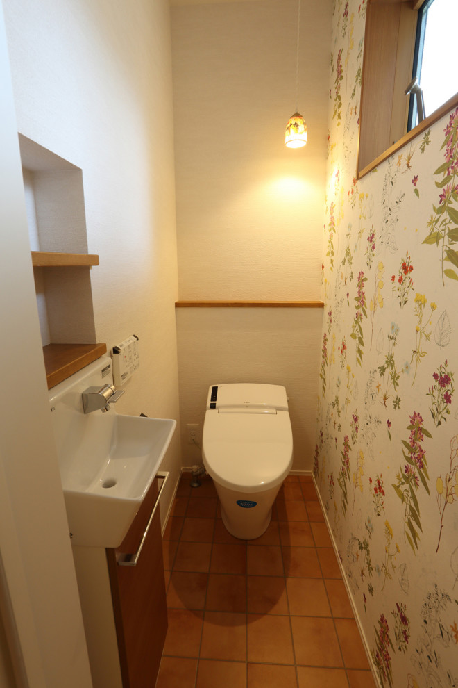 京都にあるカントリー風のおしゃれなトイレ・洗面所 (白いキャビネット、マルチカラーのタイル、茶色い床、独立型洗面台) の写真