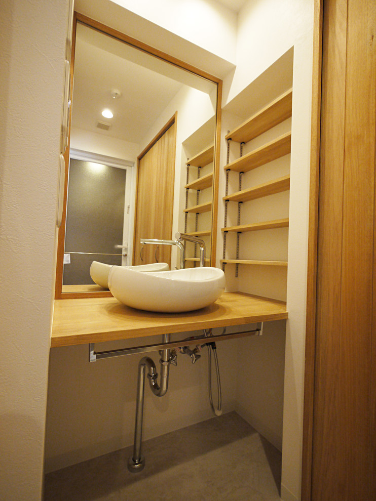 Inspiration för ett lantligt toalett, med träbänkskiva och vita väggar