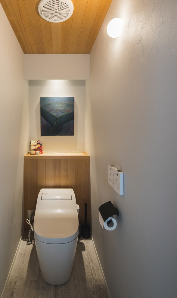 Immagine di un bagno di servizio nordico con pareti bianche, pavimento in legno verniciato e pavimento grigio