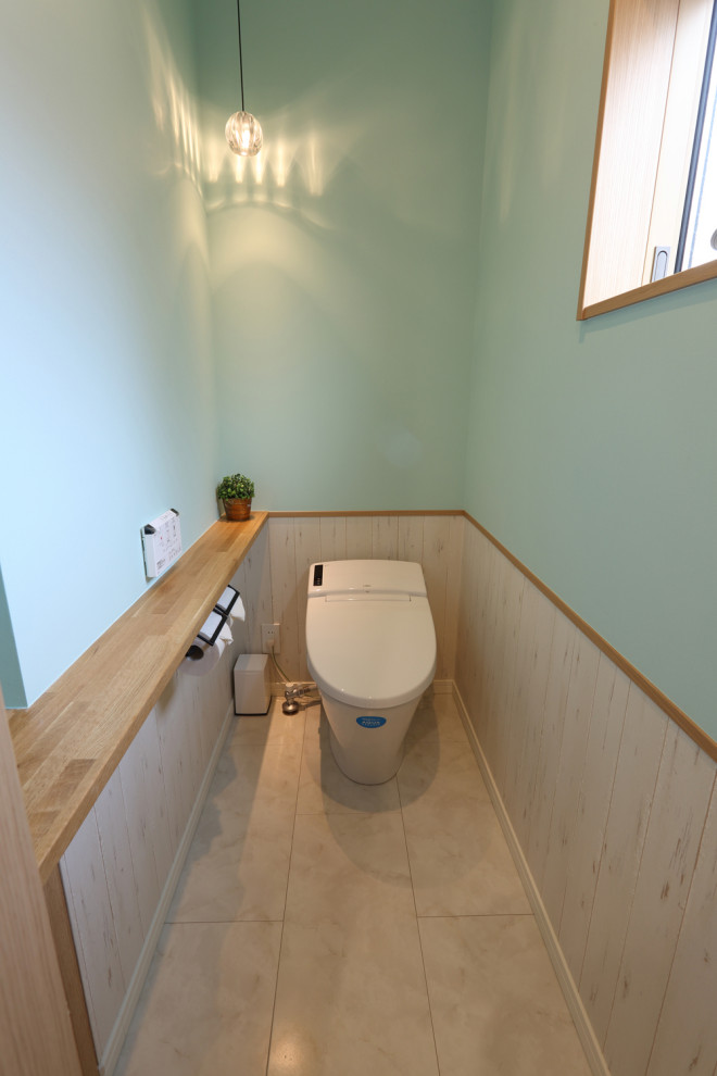 Idée de décoration pour un WC et toilettes avec un mur bleu et un sol beige.