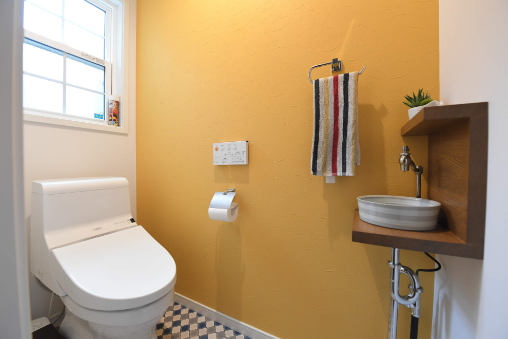 Inspiration för små minimalistiska toaletter, med en toalettstol med hel cisternkåpa och flerfärgat golv