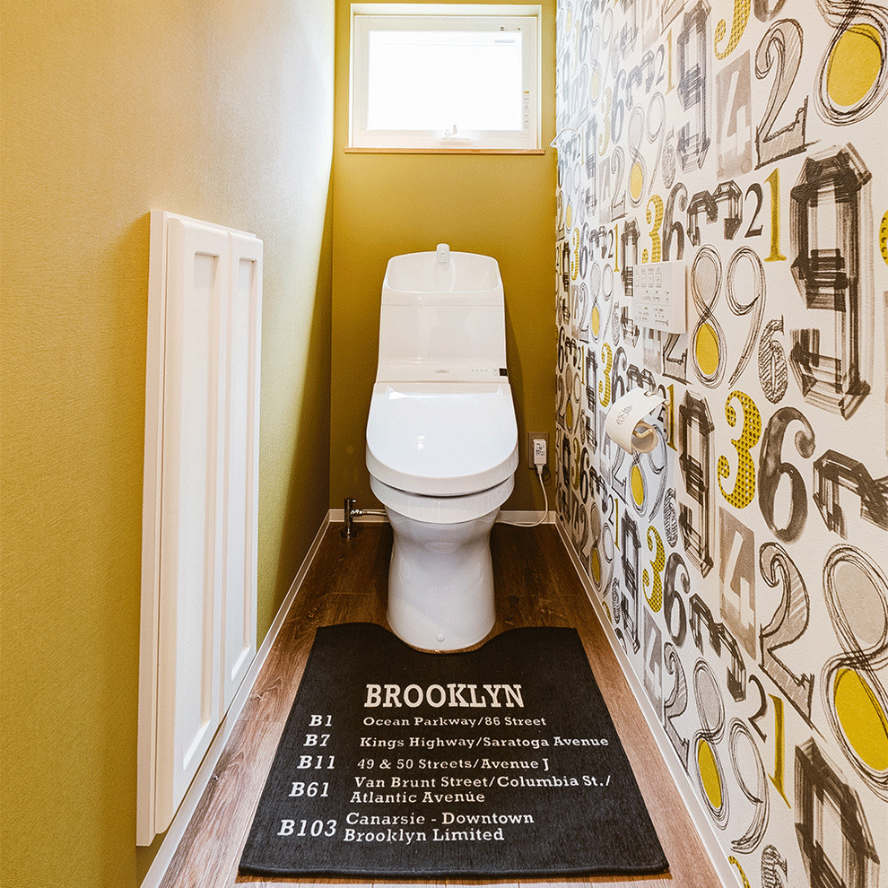 他の地域にあるトランジショナルスタイルのおしゃれなトイレ・洗面所 (落し込みパネル扉のキャビネット、白いキャビネット、黄色い壁、無垢フローリング、茶色い床) の写真