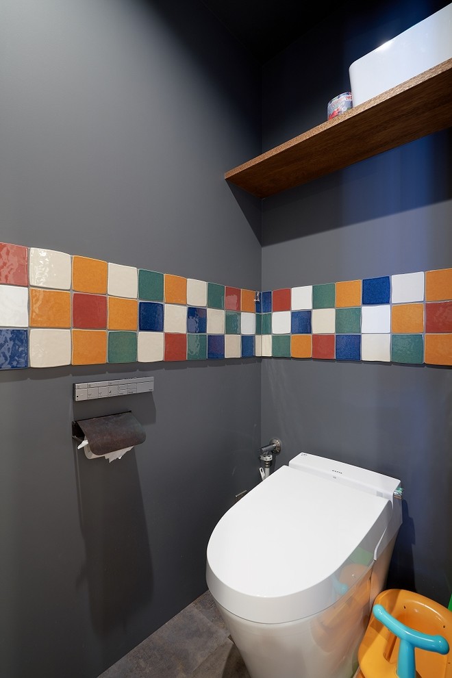 Idées déco pour un WC et toilettes moderne avec un mur gris, sol en béton ciré et un sol gris.