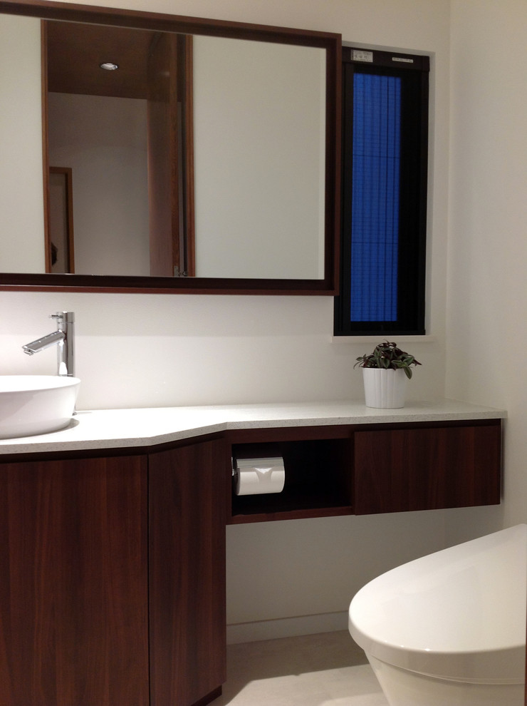 Mittelgroße Moderne Gästetoilette mit flächenbündigen Schrankfronten, dunklen Holzschränken, Toilette mit Aufsatzspülkasten, weißer Wandfarbe, Aufsatzwaschbecken, Quarzwerkstein-Waschtisch, Linoleum und weißem Boden in Tokio