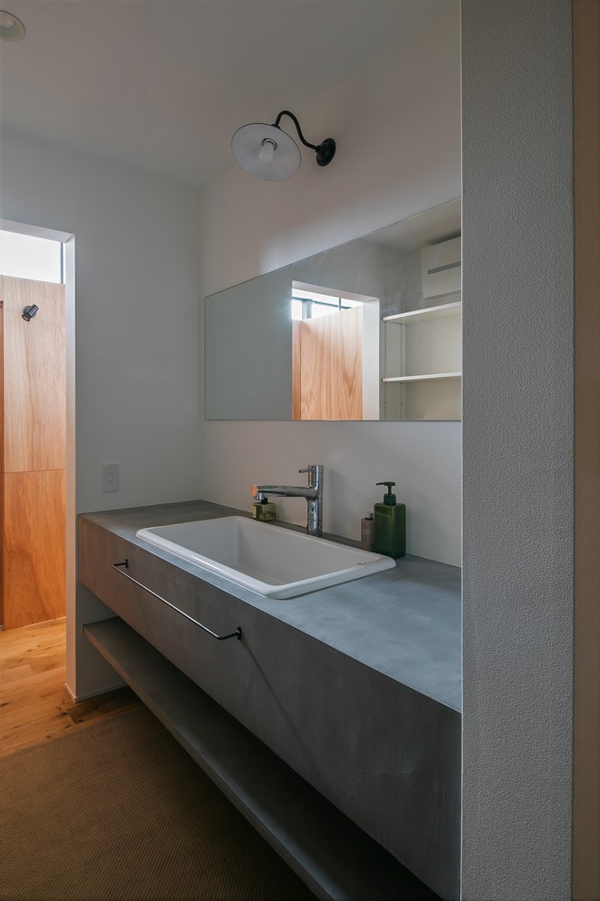 Inspiration for a medium sized rustic cloakroom in Other with open cabinets, grey cabinets, a two-piece toilet, white tiles, porcelain tiles, white walls, vinyl flooring, a vessel sink, concrete worktops, grey floors and grey worktops.
