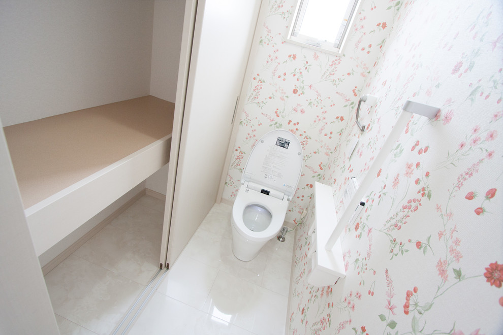 Cette image montre un petit WC et toilettes minimaliste en bois brun avec un mur blanc, un sol en contreplaqué, un lavabo intégré, un plan de toilette en surface solide et un sol blanc.