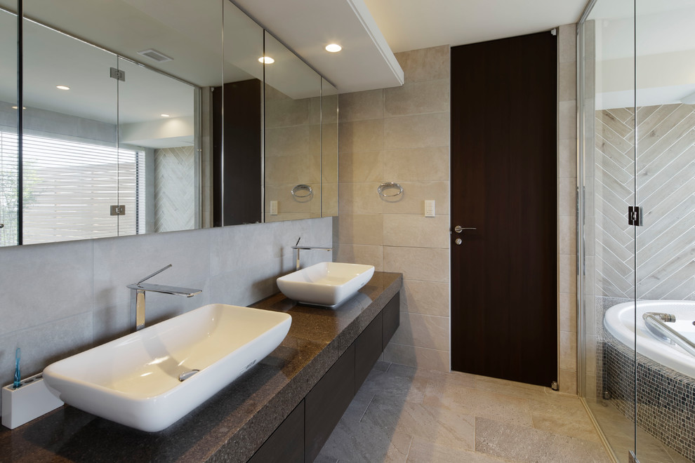 Immagine di una stanza da bagno mediterranea con ante lisce, pareti beige, lavabo a bacinella e pavimento beige