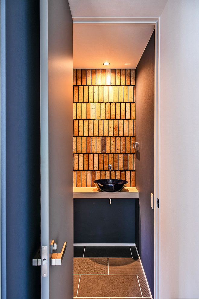 Inspiration for a contemporary cloakroom in Other with open cabinets, light wood cabinets, porcelain tiles, black walls, porcelain flooring, black floors, a built in vanity unit and a wallpapered ceiling.